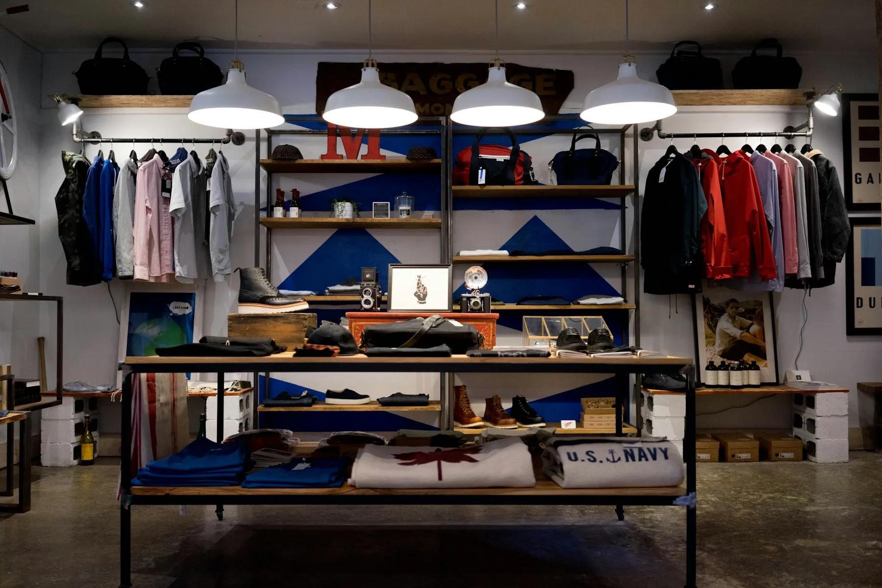 The interior of a clothing shop, rails and shelves under warm light